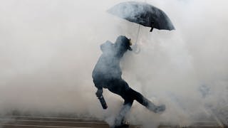 Ein Demonstrant wirft einen Tränengaskanister, während eines Zusammenstoßes mit der Polizei am Rande einer Demonstration in Frankreich.