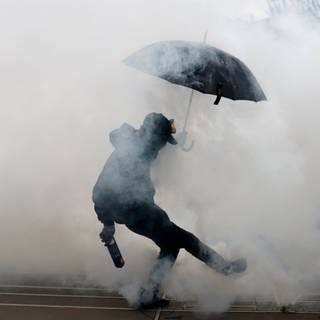 Ein Demonstrant wirft einen Tränengaskanister, während eines Zusammenstoßes mit der Polizei am Rande einer Demonstration in Frankreich.