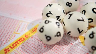 Lotto-Kugeln auf einem Schein "6 aus 49"