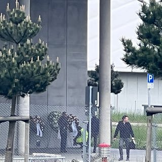 Trauer um die Toten: An der Werkshalle von Mercedes-Benz in Sindelfingen, in der am Donnerstag ein Mann zwei Menschen erschossen hat, hängen am Tag danach drei Kränze.