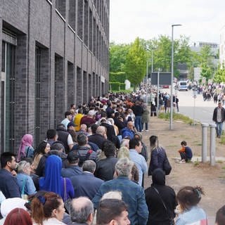 Eine lange Warteschlange hat sich vor dem Wahllokal in Stuttgart-Zuffenhausen gebildet.