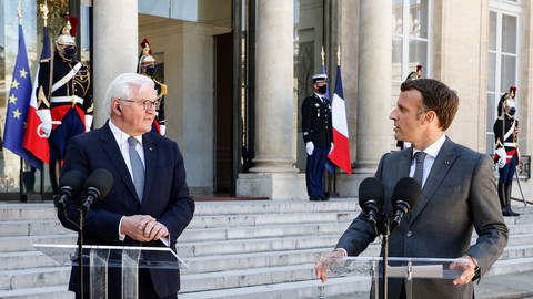 Bundespräsident Frank-Walter Steinmeier (r) begrüßt 2021 Emmanuel Macron, Präsident von Frankreich, im Schloss Bellevue.