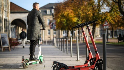 Ein Mann fährt mit einem E-Scooter durch die Innenstadt von Stuttgart.