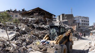 Durch die Altstadt fährt ein Bagger, der Schutt aus der Stadt trägt.