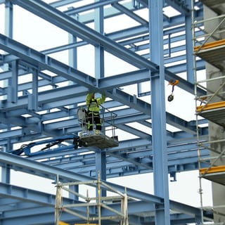 Ein Mann montiert etwas in luftiger Höhe in einem Neubau eines Gas-Werkes der EnBW.