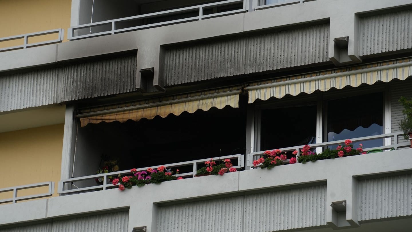 Schwarze Brandstellen sind im Bereich eines Balkons eines Mehrfamilienhauses sichtbar. Nach einem Brand in einer Wohnung in Sindelfingen (Kreis Böblingen) hat die Feuerwehr eine Leiche gefunden.