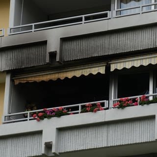 Schwarze Brandstellen sind im Bereich eines Balkons eines Mehrfamilienhauses sichtbar. Nach einem Brand in einer Wohnung in Sindelfingen (Kreis Böblingen) hat die Feuerwehr eine Leiche gefunden.