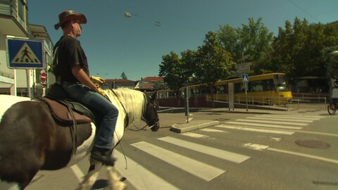 Mann reitet mit Pferd durch die Straßen von Fellbach.