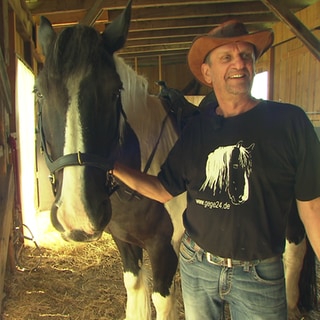 Mann reitet mit Pferd durch die Straßen von Fellbach.