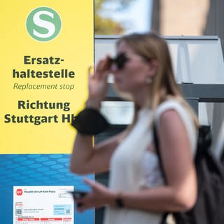 Eine Frau steht an einer provisorischen Haltestelle zum Stuttgarter Hauptbahnhof. In den Sommerferien wurde die S-Bahn-Stammstrecke gesperrt.