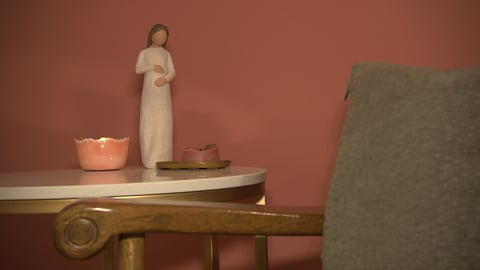 Eine Kerze, eine Schale und die Statuette einer Schwangeren schmückt einen kleinen Tisch im Geburtshaus "Amma" in Aichtal im Kreis Esslingen.
