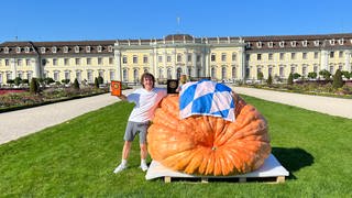 Der Sieger-Kürbis vor dem Schloss Ludwigsburg neben seinem Züchter Luca Stöckl aus Bayern: Der Atlantic-Giant brachte erstmals mehr als eine Tonne Riesenkürbis auf die Waage. 