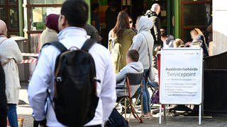 Jeden Tag warten Menschen schon Stunden vor der Öffnung vor dem Eingang der Ausländerbehörde Stuttgart. Nun will Trumpf die Stadt unterstützen, um den Engpass zu beseitigen.