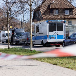 Vor Wohnhäusern in Reutlingen stehen mehrere Einsatzfahrzeuge der Polizei.