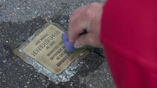 Ein Stolperstein wird geputzt. Seit 20 Jahren auf Stuttgarter Straßen: Stolpersteine gedenken an Menschen, die im Nationalsozialismus verfolgt und ermordet wurden.