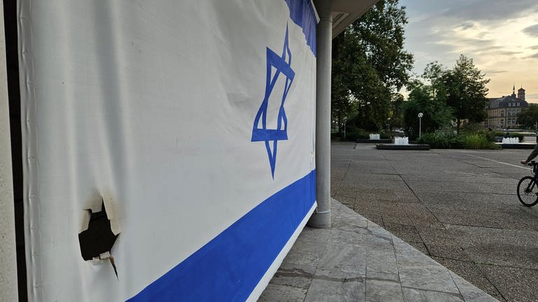 Ein Loch in einer Israel-Flagge in Stuttgart.
