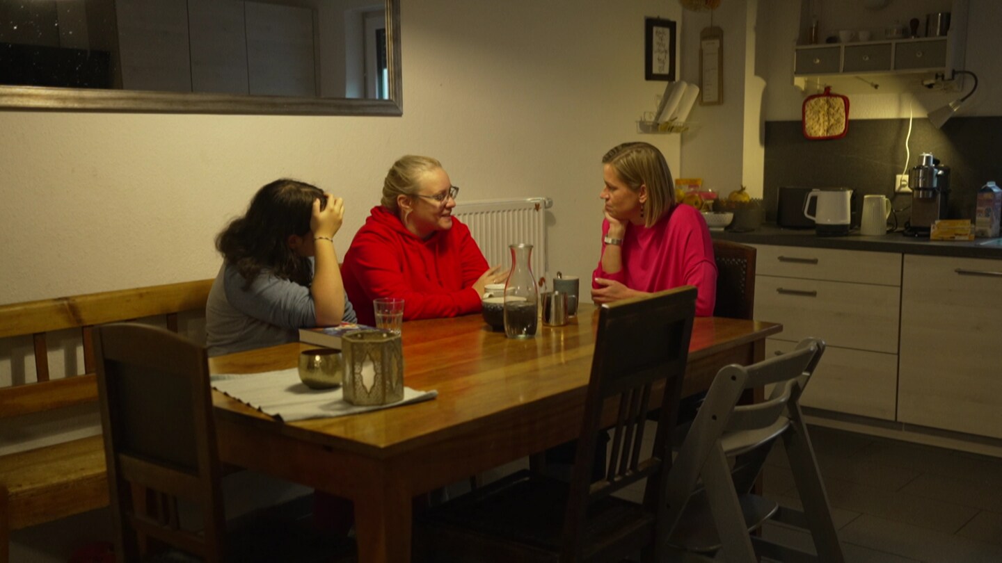 Hoffnungshaus in Leonberg: Angelika Röhm (Leonbergerin), Olga und Alisa Kladko (Ukrainerinnen) sitzen zusammen am Tisch und unterhalten sich.