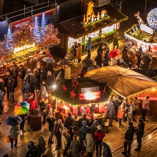 Besucher laufen über den Stuttgarter Weihnachtsmarkt.