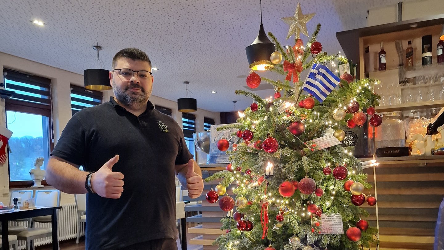 Dimitrios Evangelopoulos vor einem geschmückten Weihnachtsbaum