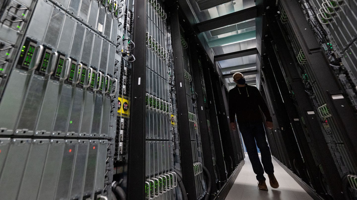 Ein Mitarbeiter des Höchstleistungsrechenzentrum Stuttgart (HLRS) läuft zwischen Rechnerschränken des Supercomuters 