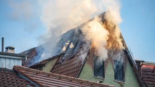 Aus einem Dach in der Esslinger Altstadt steigen dichte Rauchwolken auf. Die Feuerwehr konnte den Brand löschen.