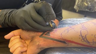 Ein Mann lässt sein Handgelenk auf der Tattoo Convetion in Göppingen tätowieren.