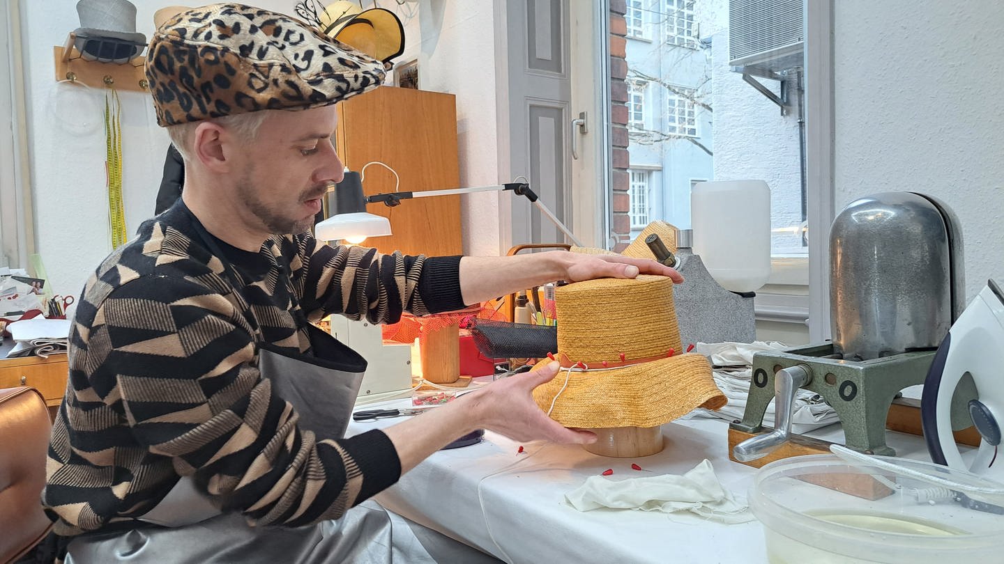 Hutmacher Michael Merten bei der Arbeit an einem Zylinder aus Florentiner Stroh in seinem Atelier in Bad Cannstatt.