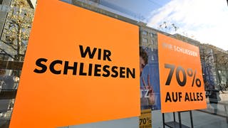 "Wir schließen" steht auf einem Schild im Schausfenster eines geschlossenen Einzelhandelsgeschäfts in der Fußgängerzone in Stuttgart.