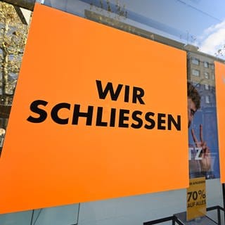"Wir schließen" steht auf einem Schild im Schausfenster eines geschlossenen Einzelhandelsgeschäfts in der Fußgängerzone in Stuttgart.