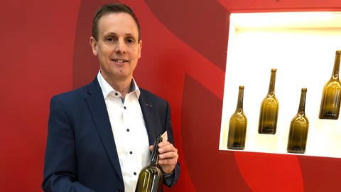 Werner Bender, Vorstand der Wein-Mehrweg eG, präsentiert auf der Fachmesse "ProWein" die neue Pfandflasche für Wein in der 0,75 Liter-Größe.