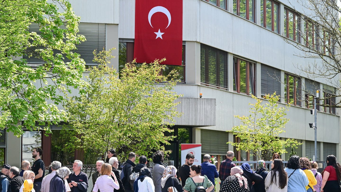 Wahlberechtigte Türkinnen und Türken stehen in Stuttgart vor einem Wahllokal zur Abstimmung für die Türkei-Wahlen.