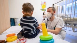 Ein Arzt untersucht in einer Kinderklinik ein Kind. Die Kliniken der Region Stuttgart sind derzeit voll mit Kindern mit dem RS-Virus - einer Atemwegserkrankung, die vor allem die Jüngsten stark trifft.