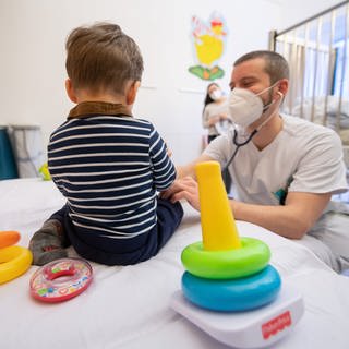 Ein Arzt untersucht in einer Kinderklinik ein Kind. Die Kliniken der Region Stuttgart sind derzeit voll mit Kindern mit dem RS-Virus - einer Atemwegserkrankung, die vor allem die Jüngsten stark trifft.