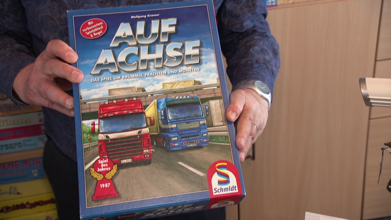 Mit dem Spiel "Auf Achse" hat Wolfgang Kramer die gleichnamige TV-Serie der ARD mit Manfred Krug verspielt - und damit das "Spiel des Jahres 1987" gewonnen. Es ist ein "Pick-up-and-Deliver"-Spiel: Auf einer Karte von Europa müssen die Spieler Waren aufsammeln und andernorts wieder abladen. Wie in der Fernsehserie eben.