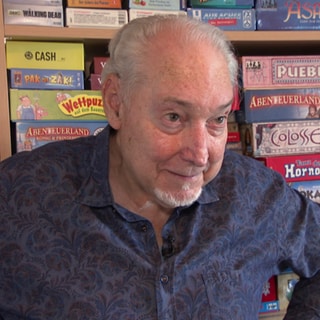 Spielerfinder Wolfgang Kramer steht vor seiner Schrankwand voller Spiele in Stuttgart-Killesberg. Der 82-Jährige hat bereits 300 Brettspiele und Kartenspiele veröffentlicht.