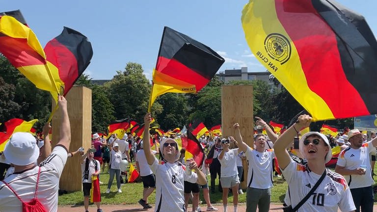 EM 2024 in Stuttgart: Fans schwenken Deutschland-Flaggen zur EM-Tor-Hymne "Major Tom".