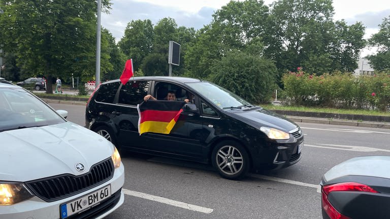Fans zeigen sich mitunter auch flexibel: Dieser feiert den Sieg der deutschen Mannschaft und das Unentschieden für die Albaner. Korso bleibt Korso - und wozu hat man denn sonst zwei Fahnen? Übrigens: Viele albanische Fans waren in Stuttgart beim Feiern dabei.