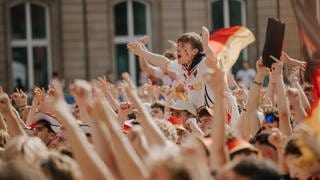 Fans auf dem Schlossplatz in Stuttgart jubeln Deutschland beim Public Viewing zu.