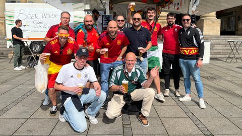 Das erste Bier schon um 10 Uhr: deutsche und spanische fans stoßen auf dem Schlossplatz gemeinsam an.