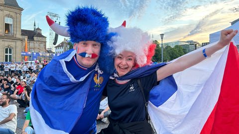 Auf dem Schlossplatz in Stuttgart läuft nun das zweite Viertelfinale Frankreich gegen Portugal. Kevin und Elena fiebern für die Grande Nation.