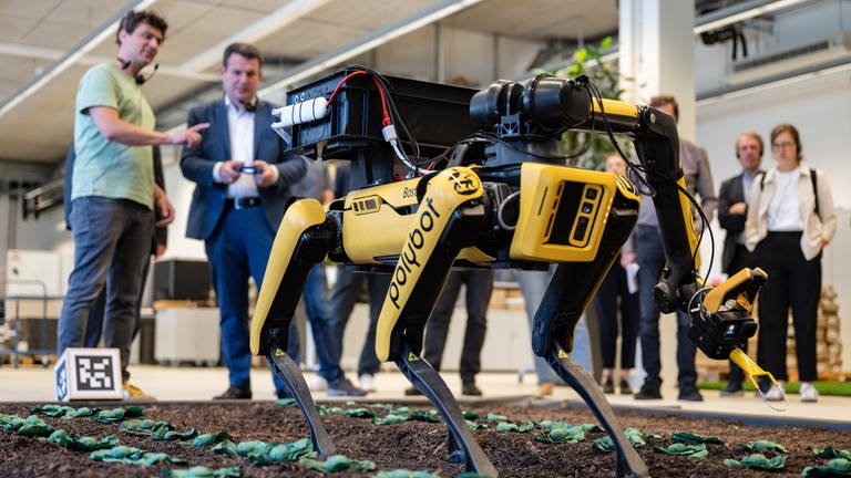 Hubertus Heil, Bundesminister für Arbeit und Soziales schaut sich einen KI-Roboter für die Landwirtschaft an