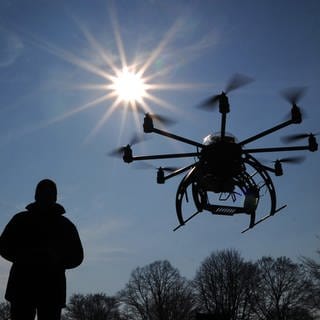 Zwei Menschen, die eine Drohne fliegen lassen (Symbolbild)