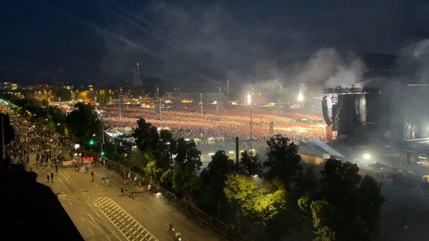 Menschenmassen werden beim AC/DC-Konzert in Stuttgart von Scheinwerfern angestrahlt.