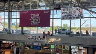 Im Stuttgarter Flughafen sind Klimaaktivisten der sogenannten "Letzten Generation" auf einen Vorsprung geklettert und haben drei Plakate aufgehängt.