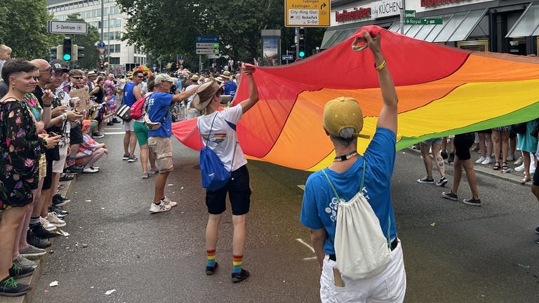 Eine Regenbogenfahne in riesig beim Umzug des CSD 2024 durch Stuttgart.