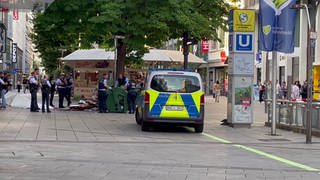 Polizistinnen und Polizisten stehen bei einem Einsatz auf der Stuttgart Königsstraße. Bei einer Auseinandersetzung mit einem Messer sind mehrere Personen teils lebensgefährlich verletzt worden. 