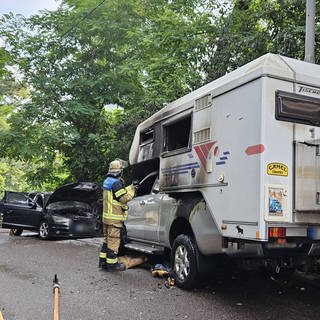 Zwei verbrannte geparkte Autos stehen in Stuttgart Ost am Straßenrand, ein Feuerwehrmann inspiziert das eine Wrack: Wohl ein Serientäter hat in Stuttgart an drei Tagen infolge mehrere Autos in Brand gesetzt.