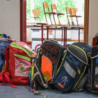 Rucksäcke von Kindern vor einem Klassenzimmer in einer Grundschule