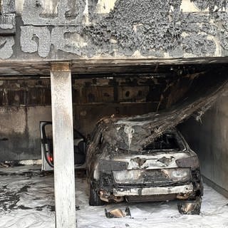 Ausgebranntes und mit Löschschaum besprühtes Auto in Stuttgart-Feuerbach.