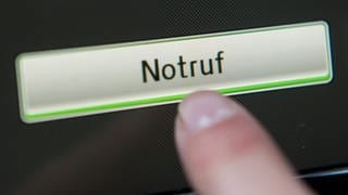 Ob als verbauter Knopf oder wie hier über den Display eines Bordcomputers: Bei Unfällen wird durch das eCall-System der Notruf aktiviert.